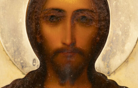 Detailaufnahme eines religiösen Gemäldes, das ein Porträt von Jesus Christus zeigt. Deutlich zu erkennen sind der ernste Blick und der volle Bart. Hinter dem Haupt von Jesus ist ein heller, runder Nimbus zu sehen, der Heiligkeit symbolisiert. Die Farbgebung ist warm mit sanften Erdtönen und sanften Highlights auf dem Gesicht und in den Haaren.