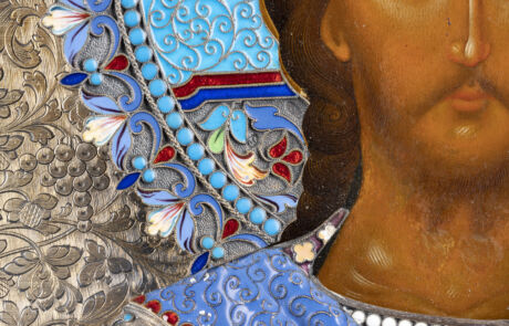 Nahaufnahme eines detailreichen Gemäldes mit dem Porträt eines Mannes, dessen Gesichtszüge fein dargestellt sind. Er trägt eine kunstvoll verzierte blaue und rote Kleidung mit Perlenschnüren und floralen Mustern in Blau, Weiß und Rot auf silbernem Hintergrund.